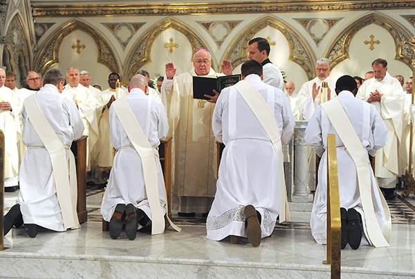 Bishop Richard J. Malone blesses the four new priests Father Gerard Skrzynski, Father Peter Santandreu, Father Paul Stanislaw Cygan, and Father Peter Nsa Bassey during a Mass at St. Joseph Cathedral. (Dan Cappellazzo/Staff Photographer)